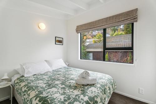 a bedroom with a bed and a large window at Lake and Mountain Views - Central Queenstown in Queenstown