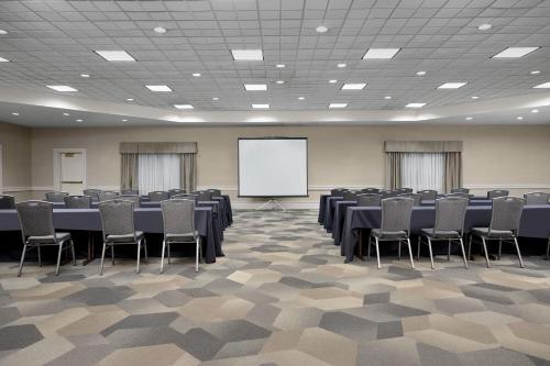 a conference room with tables and chairs and a whiteboard at SpringHill Suites Boston Peabody in Peabody
