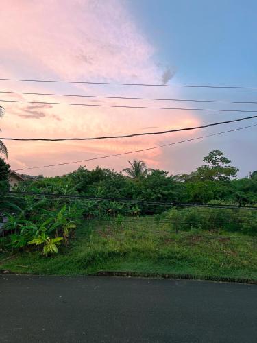 a view of a road with a sunset in the background at Bliss Oasis Hideaway in Buccoo