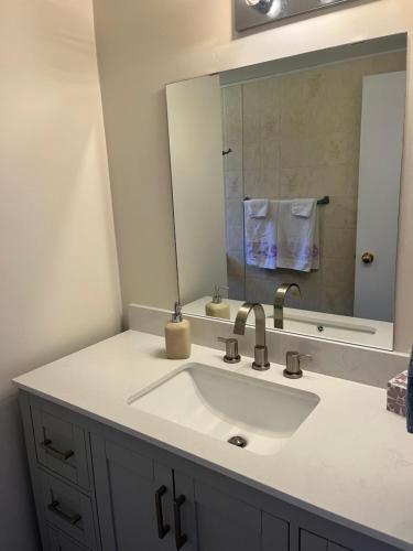 un baño con lavabo y espejo en Waterfront, Mountainview House in Castlegar, en Castlegar