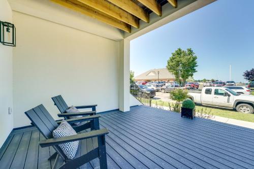two chairs on a deck with a view of a parking lot at Modern Ludington Condo Across From the Lake! in Ludington