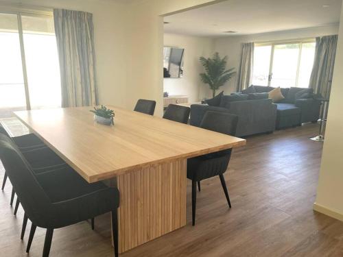 a living room with a wooden table and chairs at Hughes by the Sea in Port Moonta
