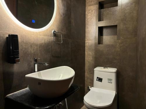a bathroom with a sink and a toilet and a mirror at Vintage River Homestay in Varanasi