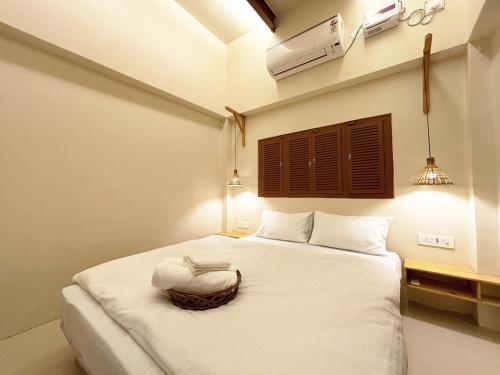 a bedroom with a white bed with a towel on it at Vintage River Homestay in Varanasi