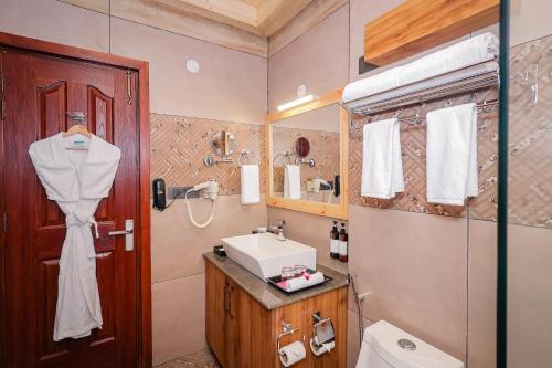 a bathroom with a sink and a toilet at Regenta Resort MARS Valley View Shoghi in Shimla