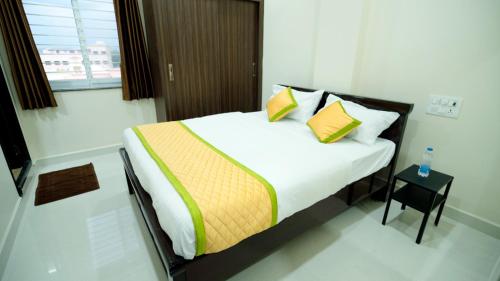 a bedroom with a large bed with yellow and green pillows at Divya Comforts- 2BHK in Tirupati