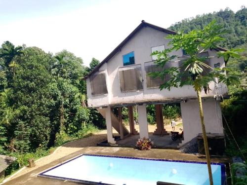 a house with a swimming pool in front of it at Kit Cott Resort and Retreat in Teligama