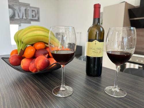 two glasses of red wine next to a bowl of fruit at Große Ferienwohnung Gästehaus NEUBAU Merzig 120m2 in Merzig