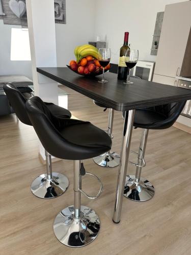 a table with a bowl of fruit and a bottle of wine at Große Ferienwohnung Gästehaus NEUBAU Merzig 120m2 in Merzig