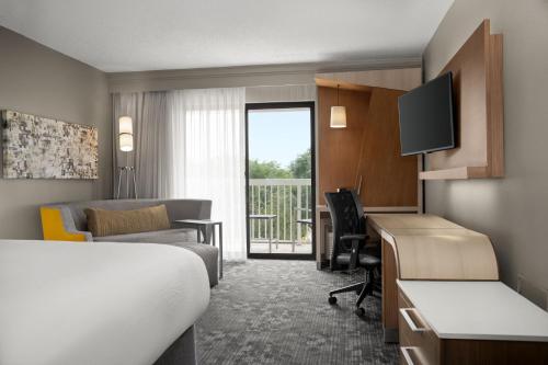 a hotel room with a bed and a desk at Courtyard Lafayette Airport in Lafayette