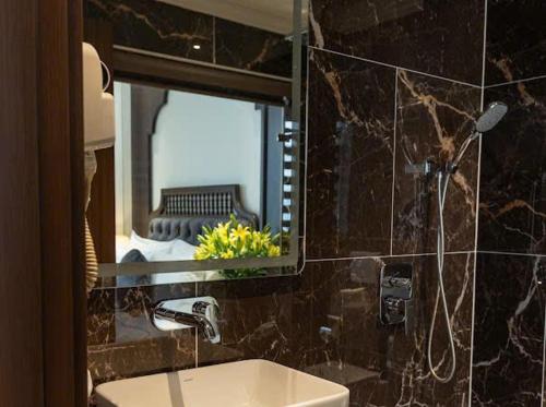 a bathroom with a mirror and a sink and a sink at Hoàng Gia Xa La Boutique Hotel in Hanoi