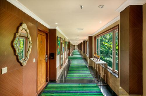 a hallway in a building with green carpeted floors and windows at Mayfair Lagoon in Bhubaneshwar