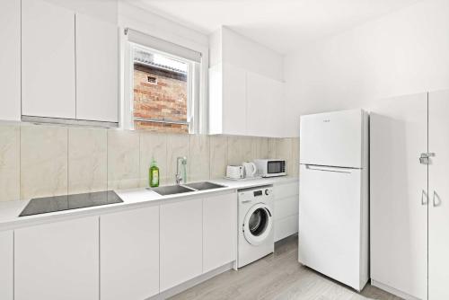 a white kitchen with a refrigerator and a washing machine at Rustic Double Room - Central Location in Kensington - Shared Bathroom in Sydney