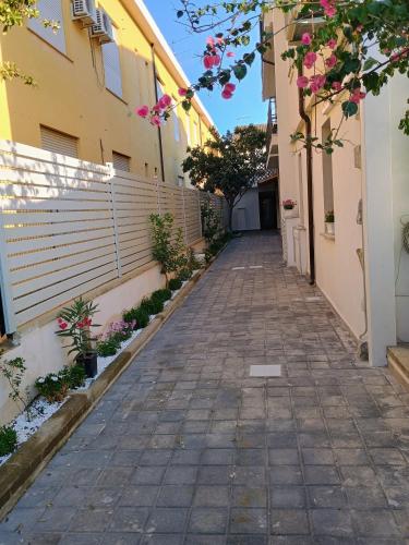 an alley between two buildings with pink flowers at Harmony Affittacamere in Tortolì
