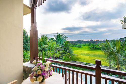 a balcony with a table with flowers on it at Bliss Ubud Spa Resort in Ubud