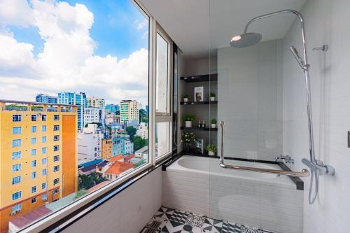 une salle de bain avec baignoire et une grande fenêtre dans l'établissement Léman Luxury Apartment District 3 HCMC, à Hô-Chi-Minh-Ville