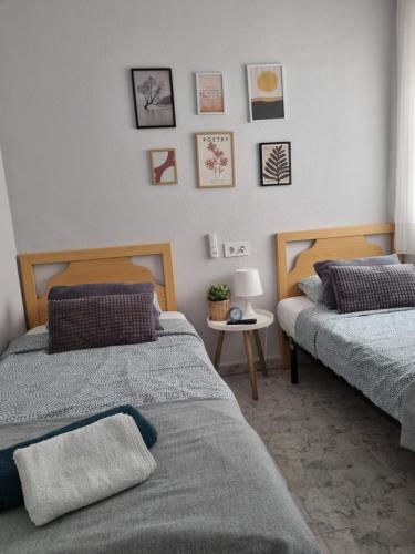 sypialnia z 2 łóżkami i małym stołem w obiekcie Apartment Amelia w mieście La Mata