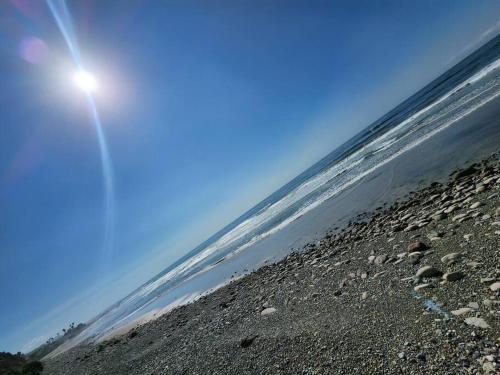 a view of a beach with the sun in the sky at Casa de Playa en Puerta del Mar in Rosarito