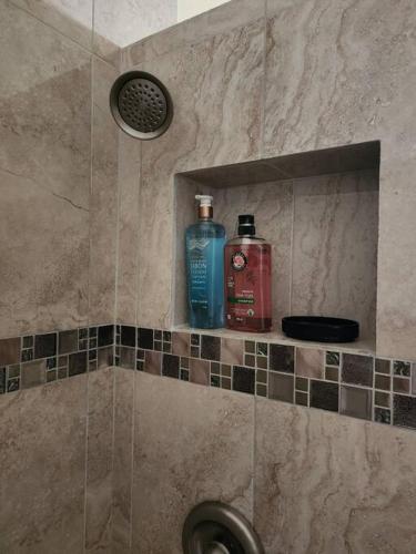 two bottles ofodorizers sit on a shelf in a shower at Casa de Playa en Puerta del Mar in Rosarito