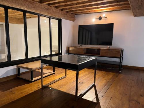 un salon avec une table noire et une télé dans l'établissement T2 avec mezzanine, à Fourvière