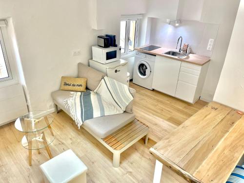 un petit salon avec un canapé et une cuisine dans l'établissement « Studio Cosy vieille ville » refait à neuf, à Menton