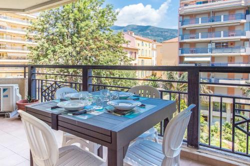 une table bleue et des chaises sur un balcon dans l'établissement Splendide 2 pièces Vue Jardin, Calme, Plein Centre, à Menton
