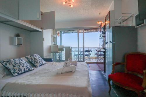 une chambre avec un ours en peluche assis sur un lit dans l'établissement « Château Saint Louis 3 » Vue Mer, Terrasse, à Menton