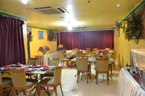 فندق انوار الضيافة في مكة المكرمة: غرفة طعام مع طاولات وكراسي مع ستائر حمراء