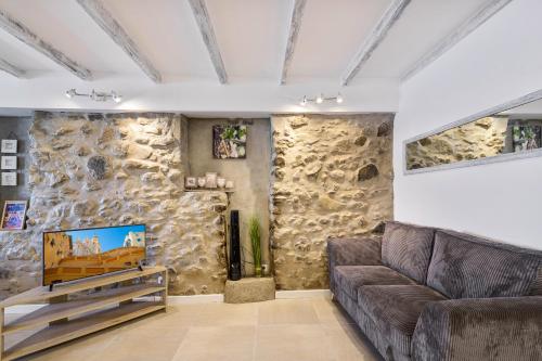 un salon avec un canapé et un mur en pierre dans l'établissement 