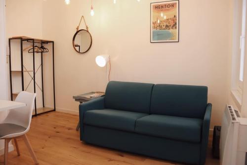 a living room with a blue couch and a mirror at "Le Massena" Plein Centre, Neuf, Proche gare in Menton