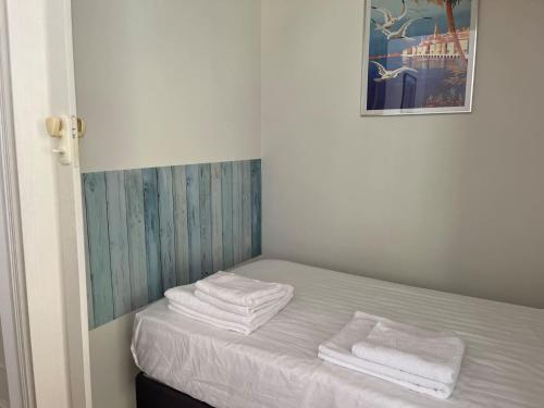 une chambre avec un lit avec des serviettes dessus dans l'établissement « Hawai » Proche Mer, Calme, Piscine, à Menton