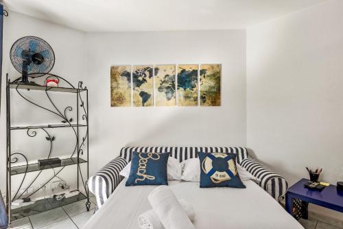 Cette chambre comprend un lit et deux peintures murales. dans l'établissement Cocon vu sur le port de menton, à Menton