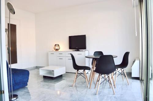 - un salon avec une table, des chaises et une télévision dans l'établissement 