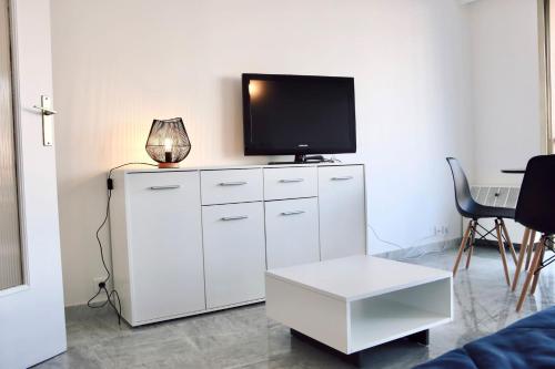 - un salon avec une télévision au-dessus d'une armoire blanche dans l'établissement 