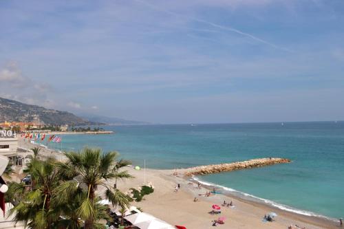 - une plage avec un groupe de personnes et l'océan dans l'établissement 2 pièces plein Centre, Terrasse, Parking, à Menton
