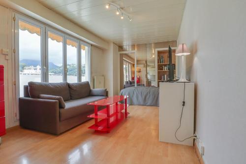 - un salon avec un canapé et une table rouge dans l'établissement Cosy studio, proche Plage et Gare, vue Montagne, à Roquebrune-Cap-Martin