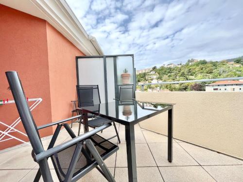 d'une table en verre et de deux chaises sur un balcon. dans l'établissement 'La Villa Melanie' Neuf, Equipé, Terrasse, Centre, à Menton
