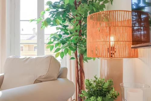 un salon avec une chaise, une lampe et une plante dans l'établissement Magnifique Appartement, plein Centre, cozy, à Menton
