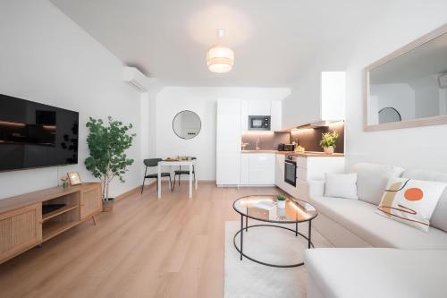 un salon blanc avec un canapé et une table dans l'établissement Cozy appartement Plein Centre, Proche Gare/plage, à Menton