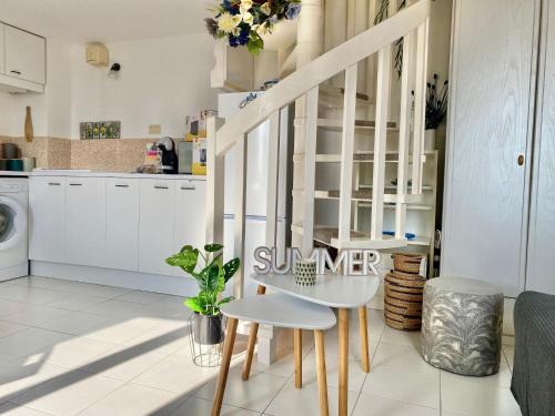 une cuisine avec des placards blancs et une table et des chaises blanches dans l'établissement 'La Villa Hygie' Cozy Appartement, Vue Mer, à Menton