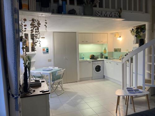 une cuisine et un salon avec une table et un évier dans l'établissement 'La Villa Hygie' Cozy Appartement, Vue Mer, à Menton