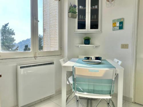 une table et deux chaises dans une pièce avec une fenêtre dans l'établissement 'La Villa Hygie' Cozy Appartement, Vue Mer, à Menton