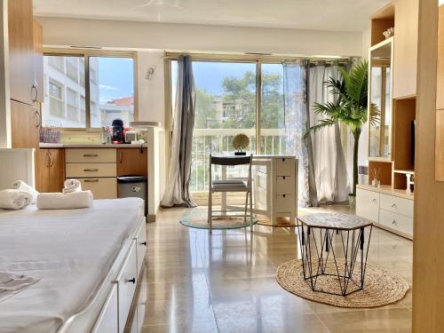 une chambre avec un lit, une table et des chaises dans l'établissement Le studio de garavan, au calme, à Menton