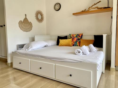 - un lit blanc avec des draps et des oreillers blancs dans l'établissement Le studio de garavan, au calme, à Menton