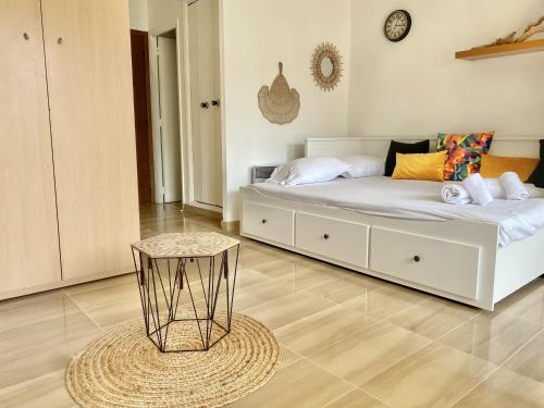 une chambre avec un lit blanc et une table dans l'établissement Le studio de garavan, au calme, à Menton