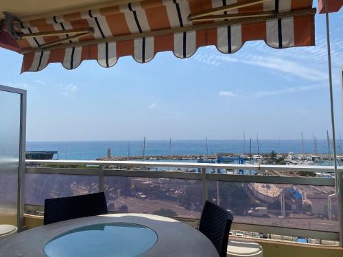 une table et des chaises sur un balcon avec vue sur l'océan dans l'établissement Le diplomat, vue mer, cosy, à Menton