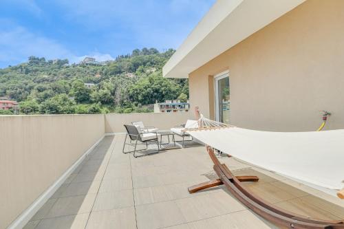 - un hamac sur un balcon avec une table et des chaises dans l'établissement Spacieux Rooftop Parking, Terrasse ensoleillée, à Menton