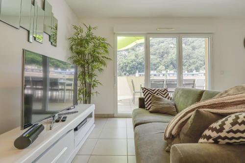 un salon avec un canapé et une télévision dans l'établissement Spacieux Rooftop Parking, Terrasse ensoleillée, à Menton