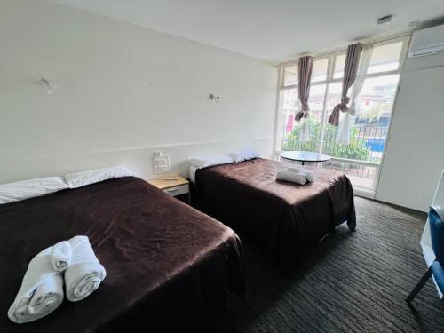 a hotel room with two beds and a window at Jacksons Motor Inn in Adelaide