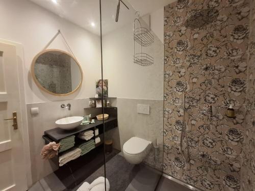 un bagno con un water, un lavandino e uno specchio di Apartment wildflower in Privatvilla im Herzen Merans a Merano